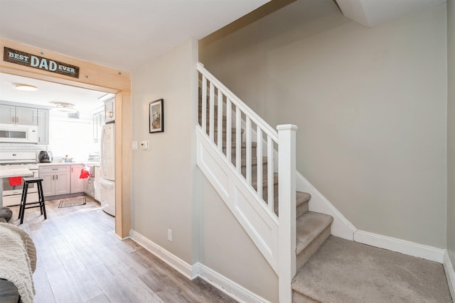 stairway with baseboards and wood finished floors