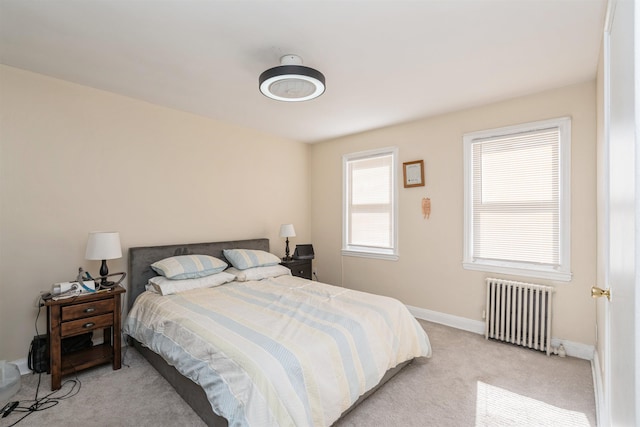 bedroom featuring radiator heating unit, baseboards, and light colored carpet