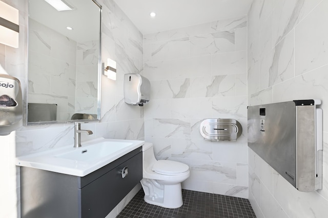 bathroom with toilet, vanity, and tile patterned floors