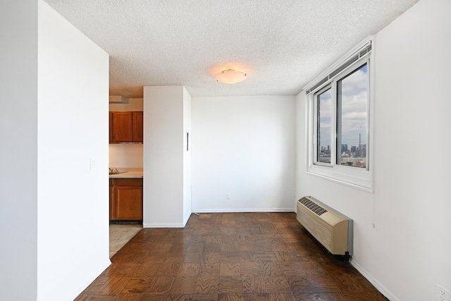 hallway with dark parquet flooring, a textured ceiling, and radiator