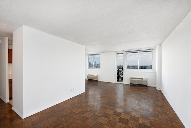 unfurnished room featuring a textured ceiling and dark parquet floors