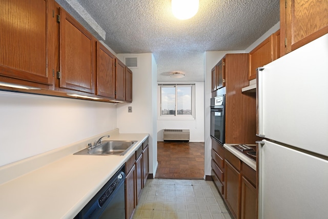 kitchen with black appliances, radiator heating unit, sink, and a textured ceiling