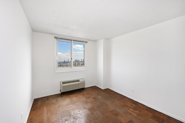 empty room featuring a textured ceiling and heating unit