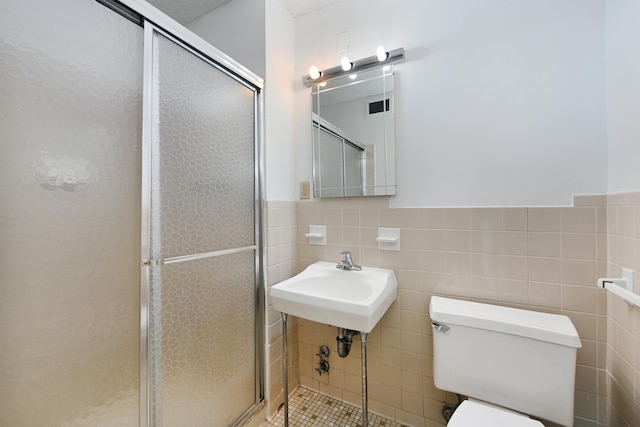 bathroom featuring an enclosed shower, toilet, and tile walls