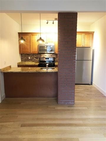 24 E 49th St, Bayonne, NJ 07002 - kitchen featuring appliances with stainless steel finishes, light wood finished floors, light stone countertops, and hanging light fixtures