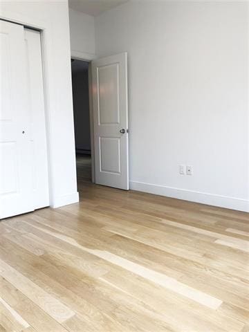 24 E 49th St, Bayonne, NJ 07002 - unfurnished bedroom featuring light wood finished floors, a closet, and baseboards