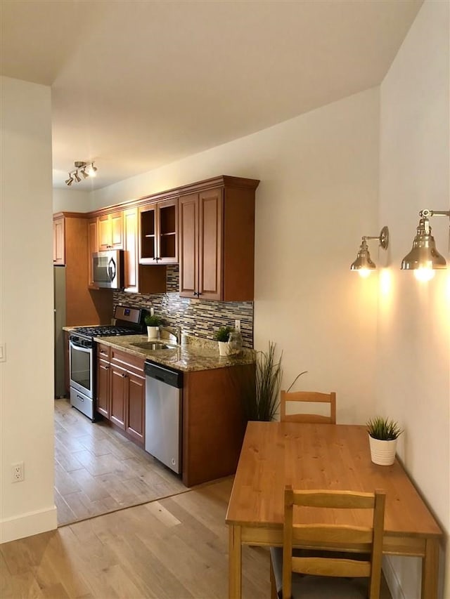 24 E 49th St, Bayonne, NJ 07002 - kitchen featuring appliances with stainless steel finishes, a sink, tasteful backsplash, stone countertops, and light wood finished floors