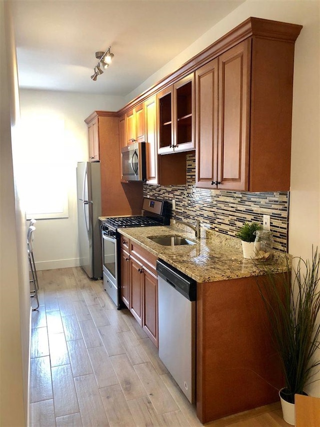 24 E 49th St, Bayonne, NJ 07002 - kitchen with appliances with stainless steel finishes, a sink, backsplash, light stone countertops, and baseboards