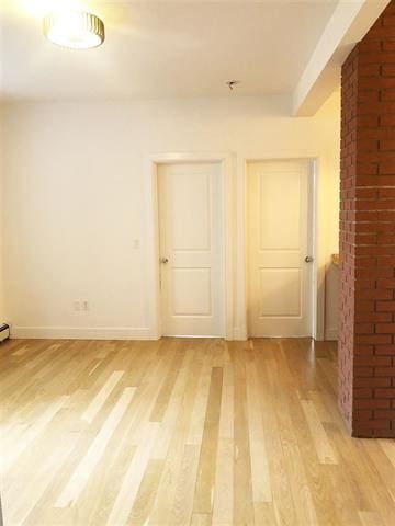24 E 49th St, Bayonne, NJ 07002 - spare room with light wood-style floors and baseboards