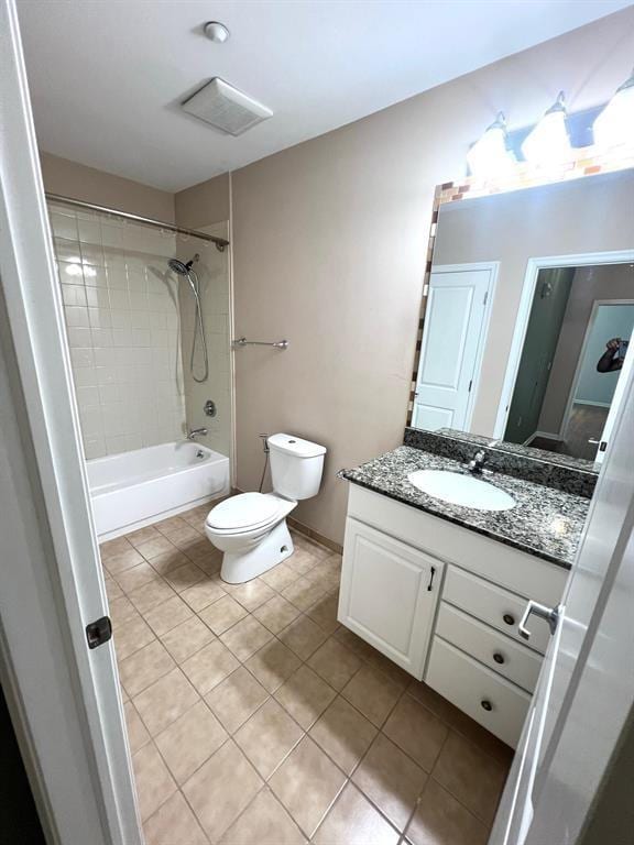 full bathroom with vanity, tiled shower / bath, tile patterned floors, and toilet