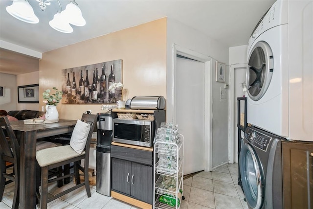 kitchen with light tile patterned flooring and stacked washer / dryer