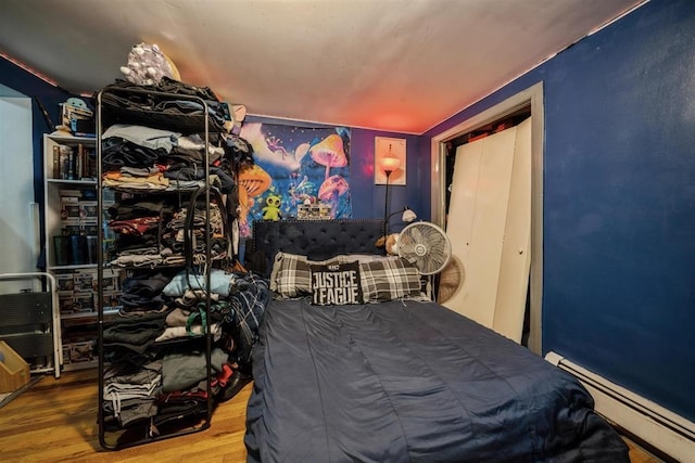 bedroom with wood-type flooring and baseboard heating