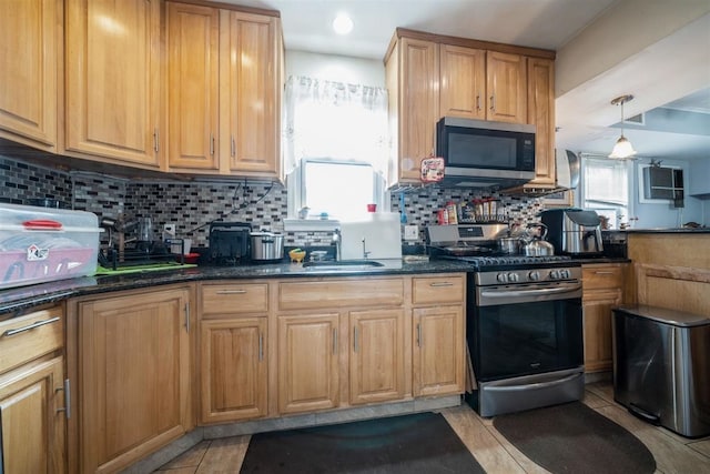 kitchen with dark stone counters, appliances with stainless steel finishes, decorative backsplash, and hanging light fixtures