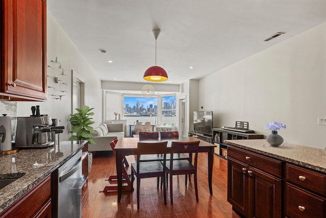 kitchen with dark stone countertops, dark wood-type flooring, visible vents, and dishwasher