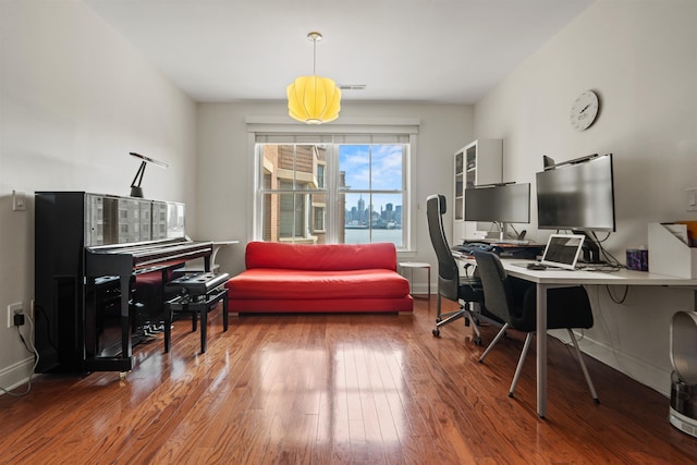 office space with visible vents, wood finished floors, and baseboards