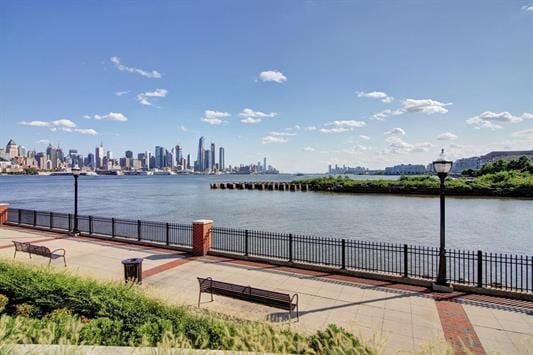 property view of water featuring fence and a city view