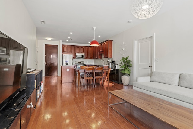 living area featuring visible vents, light wood-type flooring, and recessed lighting