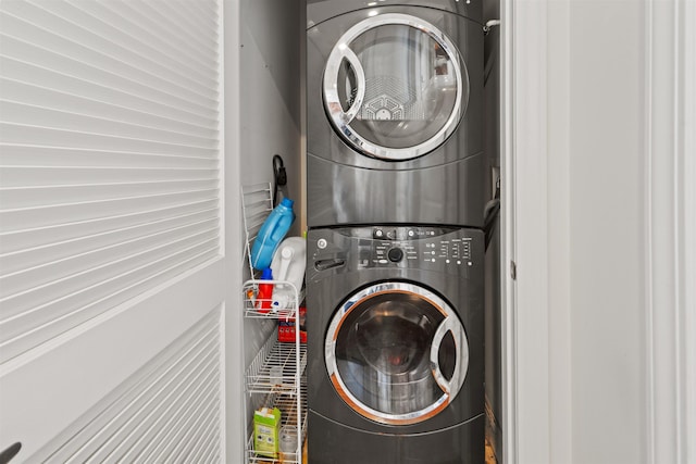 clothes washing area featuring stacked washer and dryer and laundry area