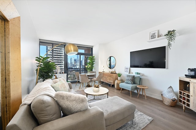 living area featuring baseboards, wood finished floors, and floor to ceiling windows