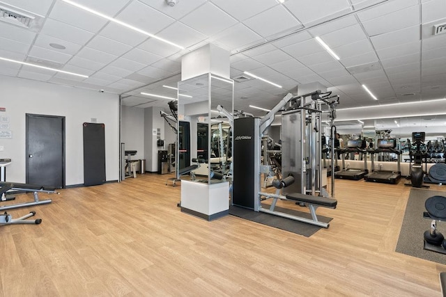 gym featuring visible vents, a paneled ceiling, and wood finished floors