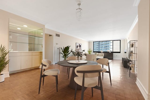 dining room with visible vents, baseboards, and ornamental molding