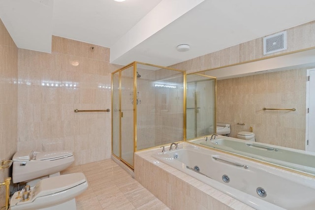 bathroom featuring a bidet, visible vents, tile walls, a jetted tub, and toilet