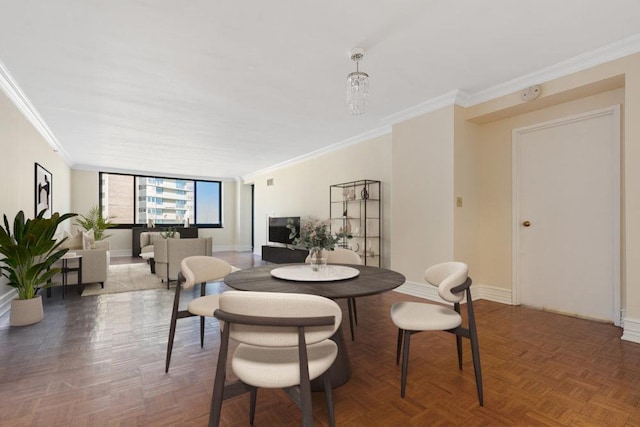 dining space with baseboards, a notable chandelier, and ornamental molding