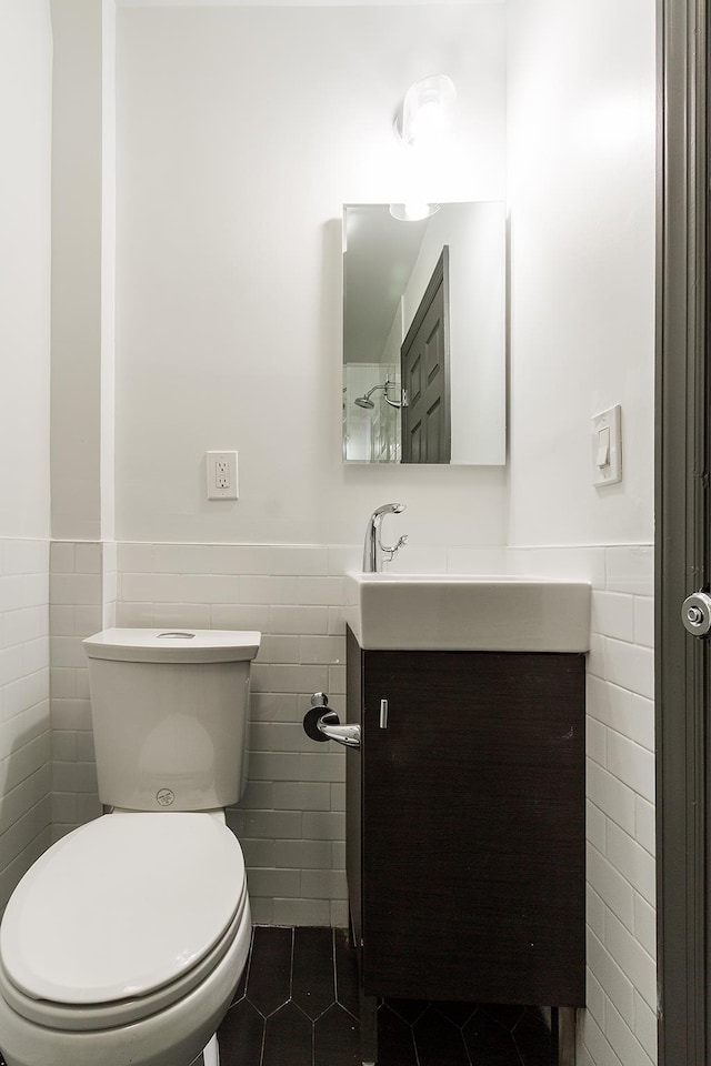 bathroom featuring tile patterned flooring, vanity, toilet, and tile walls