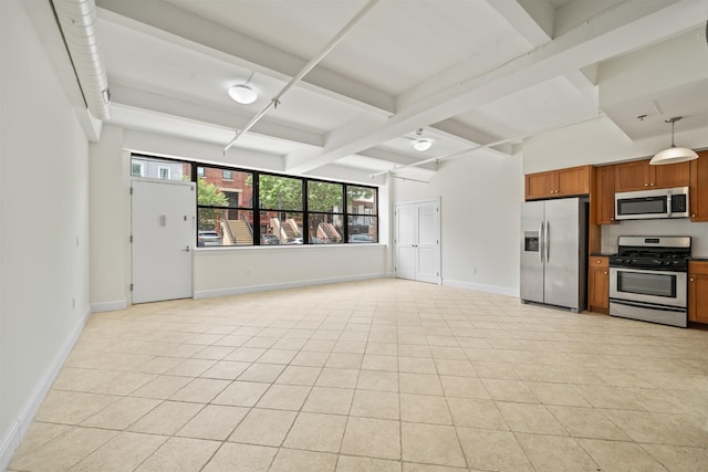 300 Communipaw Ave Unit 11, Jersey City, NJ 07304 - kitchen with stainless steel appliances, brown cabinets, beam ceiling, light tile patterned floors, and baseboards