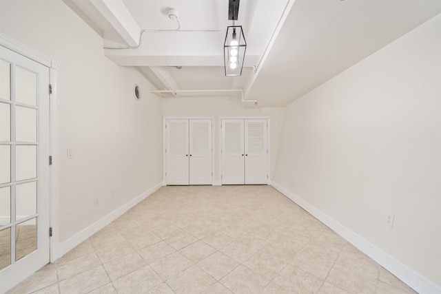 300 Communipaw Ave Unit 11, Jersey City, NJ 07304 - unfurnished bedroom with two closets, baseboards, and light tile patterned flooring