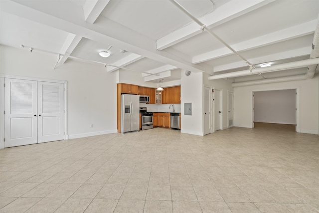 300 Communipaw Ave Unit 11, Jersey City, NJ 07304 - unfurnished living room featuring beam ceiling, baseboards, a sink, electric panel, and light tile patterned floors
