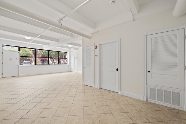 300 Communipaw Ave Unit 11, Jersey City, NJ 07304 - spare room featuring beam ceiling, light tile patterned floors, and baseboards