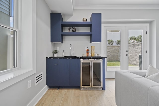 bar with blue cabinetry, wine cooler, sink, and french doors