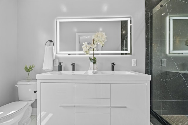 bathroom featuring vanity, a shower with shower door, and toilet