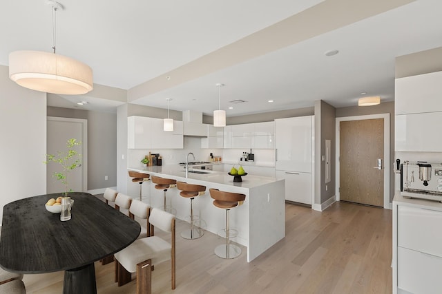 9 Avenue At Port Imperial Unit Ph8, West New York, NJ 07093 - kitchen featuring modern cabinets, a kitchen breakfast bar, light wood finished floors, white cabinets, and light countertops
