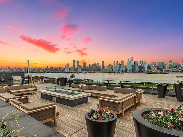 9 Avenue At Port Imperial Unit Ph8, West New York, NJ 07093 - wooden terrace with a view of skyline, an outdoor living space with a fire pit, grilling area, and a water view