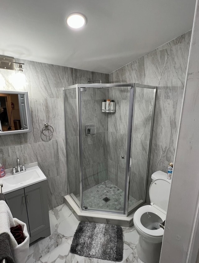 1611 71st St, North Bergen, NJ 07047 - bathroom featuring marble finish floors, vanity, a stall shower, and tile walls