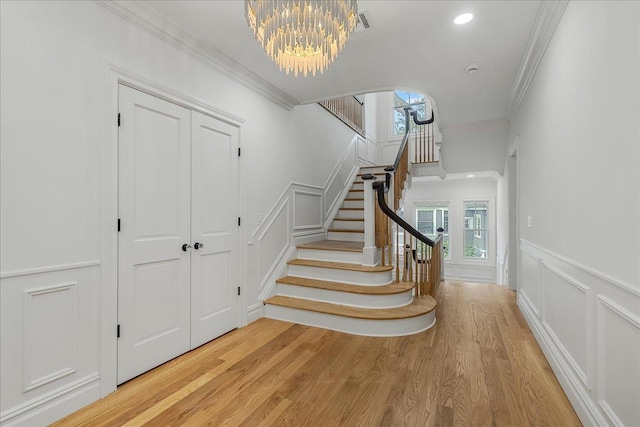 180 Union St, Montclair, NJ 07042 - stairway featuring a chandelier, wood finished floors, ornamental molding, healthy amount of natural light, and a decorative wall