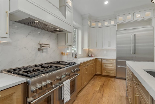 180 Union St, Montclair, NJ 07042 - kitchen featuring premium appliances, custom exhaust hood, tasteful backsplash, glass insert cabinets, and white cabinets