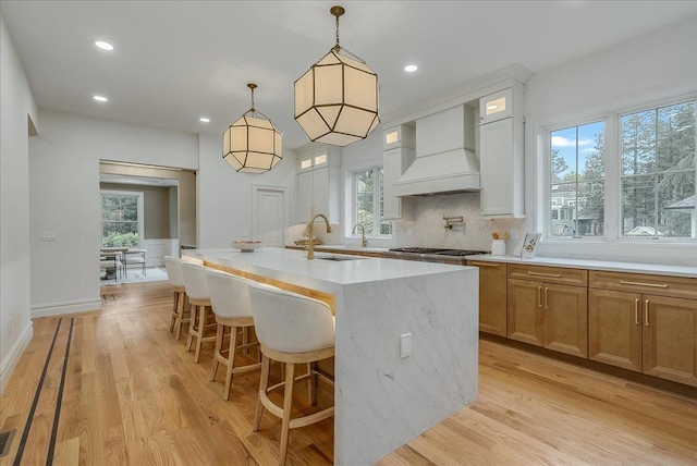 180 Union St, Montclair, NJ 07042 - kitchen with custom range hood, an island with sink, light wood-style floors, pendant lighting, and recessed lighting