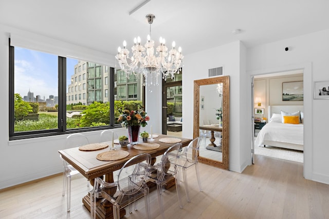 dining area featuring light hardwood / wood-style floors and a chandelier