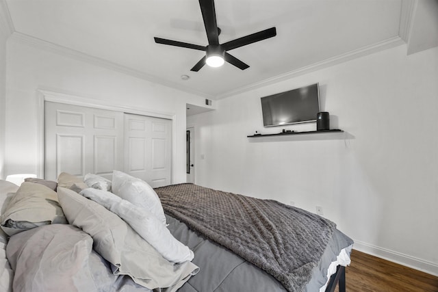 bedroom with ceiling fan, a closet, dark wood-type flooring, and crown molding