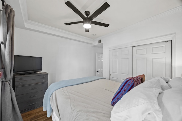 bedroom featuring ceiling fan, ornamental molding, a closet, and dark hardwood / wood-style floors