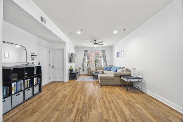 living room featuring ceiling fan, light wood-type flooring, and crown molding