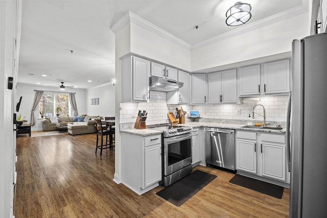 kitchen with sink, hardwood / wood-style floors, backsplash, and stainless steel appliances