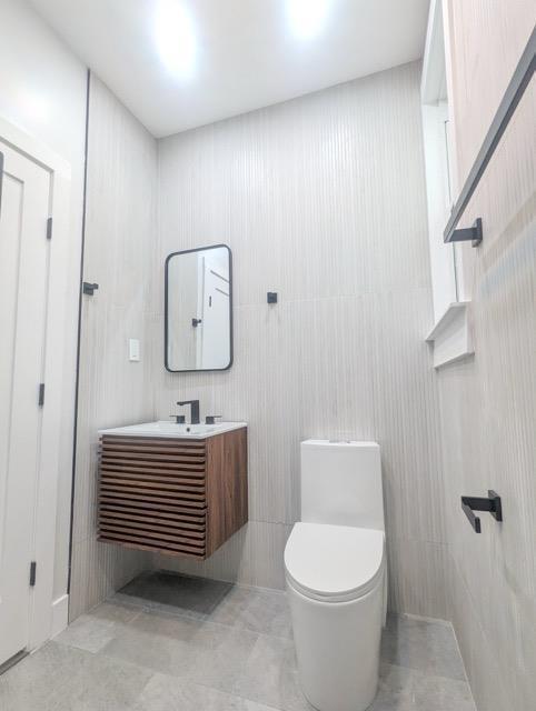 368 Palisade Ave, Jersey City, NJ 07307 - half bathroom with vanity, toilet, and tile patterned flooring