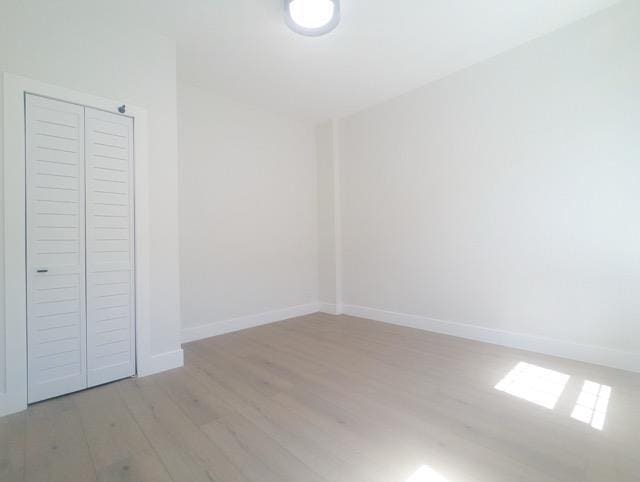 368 Palisade Ave, Jersey City, NJ 07307 - unfurnished bedroom featuring light wood-style floors, a closet, and baseboards