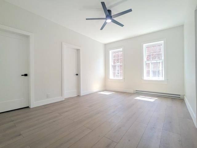 368 Palisade Ave, Jersey City, NJ 07307 - spare room featuring a baseboard radiator, a ceiling fan, wood finished floors, and baseboards