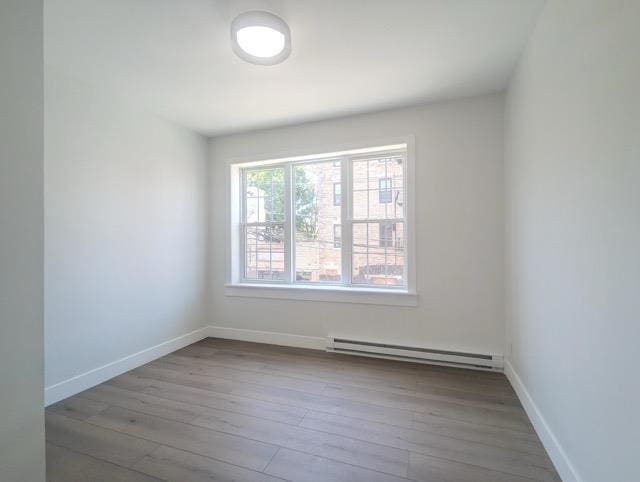 368 Palisade Ave, Jersey City, NJ 07307 - empty room featuring a baseboard heating unit, hardwood / wood-style floors, and baseboards