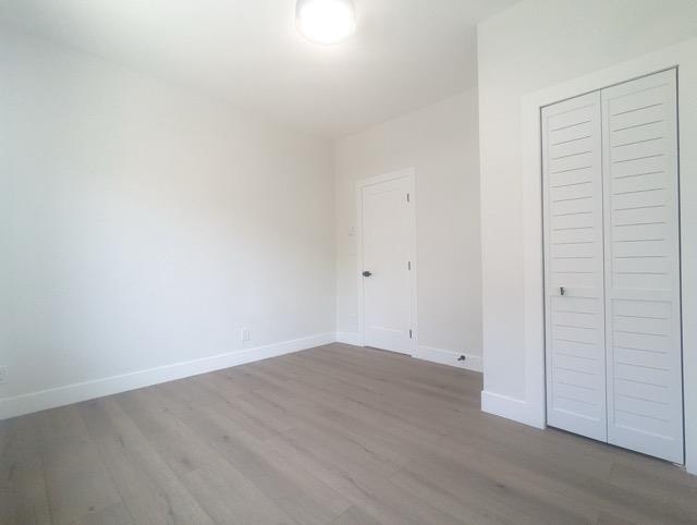 368 Palisade Ave, Jersey City, NJ 07307 - unfurnished bedroom with wood finished floors, baseboards, and a closet